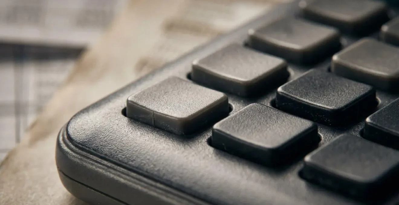 Close-up macro photograph of financial calculator keys and mortgage calculation worksheet showing DSCR formula with natural lighting